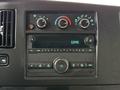 Dashboard of a 2023 GMC Savana featuring climate control dials a digital clock and an audio control panel with various buttons and a central knob