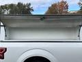 A 2020 Ford F-150 with an open truck bed cap revealing an empty cargo area