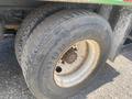 A close-up of a Goodyear tire on a 1997 Freightliner FL70 showing tread patterns and a partially rusted rim