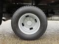 A close-up of a silver aluminum wheel with a black tire of a 2008 Ford F-350 showing the tread and lug nuts