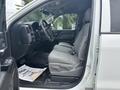 A 2016 GMC Sierra 1500 interior featuring front gray cloth seats and a dashboard with controls and display screen