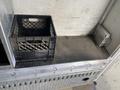 A 2015 Ford F-550 truck featuring a metal step with a black plastic crate on it