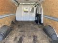 Interior of a 2022 GMC Savana van showing wooden paneling and a wooden floor with vinyl wheel well covers on either side
