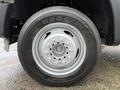 Close-up of a silver wheel with a Goodyear tire on a 2012 Ford F-450 SD showcasing five lug nuts and a plain design