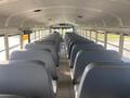 Interior view of a 2006 Thomas Saf-T-Liner HDX school bus featuring empty rows of gray seats and a flat aisle leading to the front of the bus