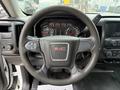 Steering wheel of a 2016 GMC Sierra 1500 with a prominent GMC logo and various controls on the wheel and dashboard display visible