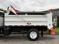 A 2012 International 7400 truck with a white dump bed and orange accents is parked with the cargo area visible