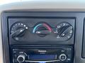 A climate control panel with three dials for fan speed temperature and various air flow options along with a Panasonic audio system below