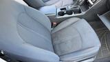 A gray cloth front seat of a 2018 Hyundai Sonata with a textured pattern and a center console featuring cup holders and storage space