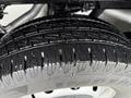 Close-up of a wet tire on a 2022 Ford Transit showcasing deep treads and a shiny surface