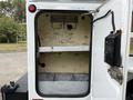 The image shows the open rear compartment door of a 2015 Ford F-350 SD with a metal frame and an empty storage area inside