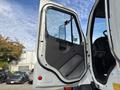 A 2013 Freightliner 114SD truck door is open showcasing the interior handle and side mirror without any occupants visible inside