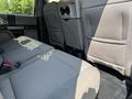 Interior view of a 2020 Ford F-350 SD showing the rear seats with gray fabric upholstery and a console between the seats