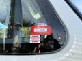 A red sticker on a vehicle window displaying a certificate of approval with the numbers 2023 and FT 84791 along with the months January February and March