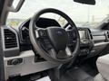 Interior view of a 2020 Ford F-550 featuring a black steering wheel with controls and a dashboard with various buttons and displays