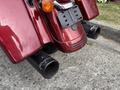 A red 2009 Harley-Davidson Road King with distinctive chrome detailing and black exhaust pipes at the rear