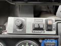 Control panel for a 2009 UD Trucks UD 3300 featuring buttons for front broom functions and a dial for front broom pressure
