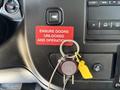 Interior dashboard of a 2020 Chevrolet Express with a key ignition and a prominent warning label stating ensure doors unlocked and operational