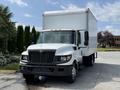 A white 2014 International TerraStar truck with a large box cargo area and front grille featuring a prominent logo