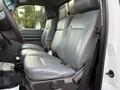 A 2015 Ford F-350 front passenger seat with gray leather upholstery and a key in the ignition