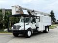 A white 2006 International 4300 utility truck with a raised aerial lift and a storage compartment on the side