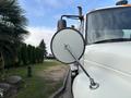 A 2012 International DuraStar 4300 with a side mirror extending from the cab and details of the vehicle visible