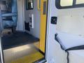 Interior view of a 2011 Chevrolet Express showing a step entry with a diamond plate surface and yellow flooring with a safety strap on the side