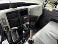 The interior dashboard of a 2012 International TerraStar featuring a gear shifter a control panel and a screen mounted on a stand