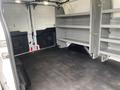 A 2017 Ford Transit van interior featuring empty shelves on one side and a black rubber floor with no cargo present