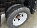 Close-up of a wheel featuring a treaded tire mounted on a white rim part of a 2011 Dodge Ram 5500
