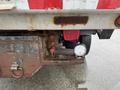 A close-up of a 2011 Dodge Ram 5500 showing the rear undercarriage with rusted components and a mounted round light next to a red reflector