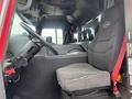 The interior of a 2006 E-One Typhoon fire truck featuring a driver's seat with a grey fabric cover and a black dashboard with control elements