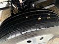 Close-up of the tire on a 2024 RAM 5500 showing treads with small pebbles and water droplets on the surface