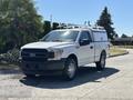 A white 2019 Ford F-150 with a rental canopy parked with a black front grille and chrome accents