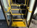 A set of yellow and black stairs leading into the open door of a 2016 Ford Econoline van