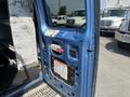A blue 2005 Ford Econoline cargo van with the door open showing an interior space and a control panel mounted on the side door