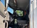 Interior view of a 2015 Peterbilt 337 truck showing the driver's seat steering wheel and dashboard in a spacious cabin layout