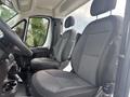 Interior of a 2023 RAM Promaster 3500 showing two front seats with a black and gray fabric design and a compact center console between them