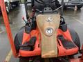 A 2010 Kubota F3680 lawn mower with a red body and a worn dashboard featuring controls and a headlight in the center