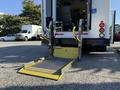 A 2016 Ford Econoline with a wheelchair lift extending from the rear vehicle entrance