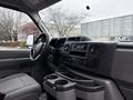 Interior view of a 2024 Ford E-450 with a dashboard featuring audio controls and cup holders in the foreground