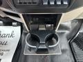 The image shows the center console of a 2009 Ford F-450 Super Duty featuring dual cup holders and an open storage compartment above them
