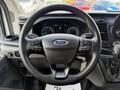 Black steering wheel of a 2021 Ford Transit with control buttons and the Ford logo visible in the center.