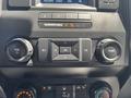 Dashboard controls of a 2019 Ford F-150 including volume and tuning knobs as well as a directional keypad and airbag indicator