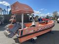 A 2007 Fassmer 20 Foot Fast Rescue Boat in bright orange with a central console and two outboard motors on the stern