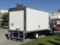 A 2017 Freightliner M2 106 box truck with a white cargo container and a gray chassis is parked with its rear facing the viewer
