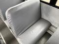 A gray vinyl seat in a bus with a smooth surface and a slight curve at the back
