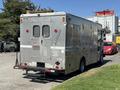 A silver 2009 Morgan Olson Workhorse W62 delivery truck with rear access doors and multiple compartments on the side
