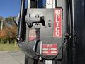A close-up of a WALTCO lift gate mechanism featuring logos and identification tags attached to metal components