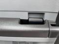 Close-up of the armrest of a 2013 Ford F-250 SD featuring a textured surface and a built-in cup holder opening